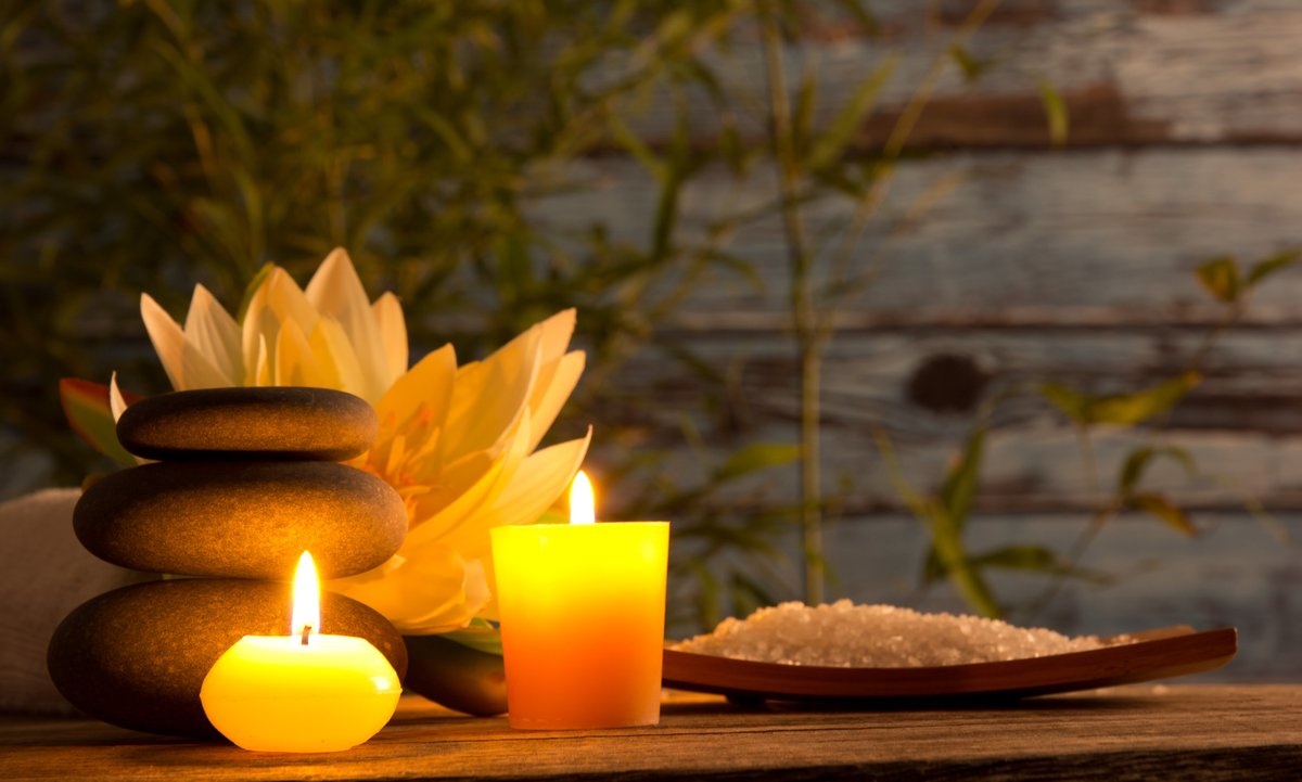 Zen spa setting with hot stones, candles, and lotus flower